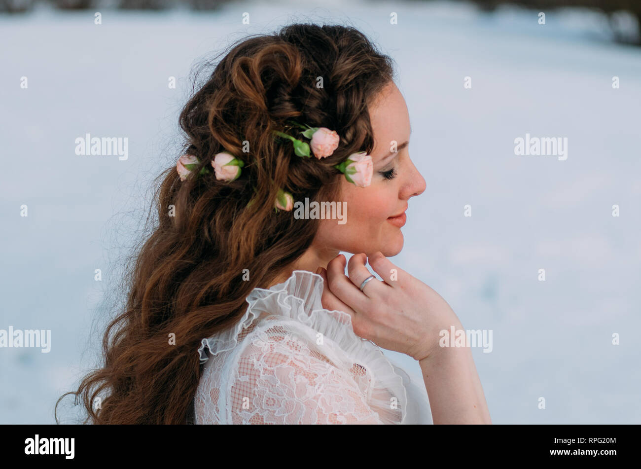 Portrait de mariée en hiver avec des roses dans les cheveux Banque D'Images