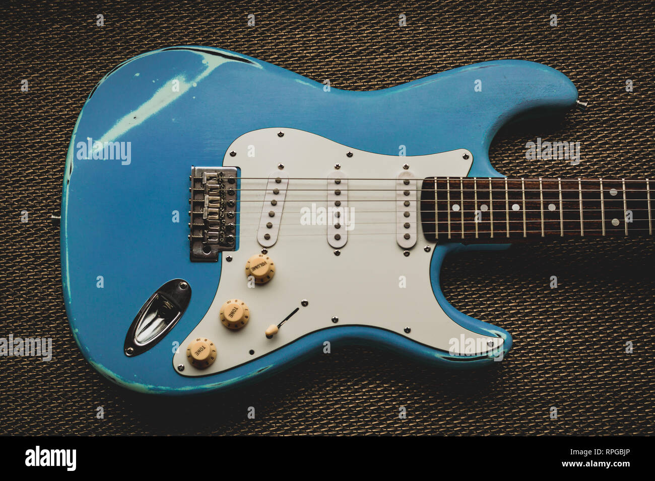 Blue guitare électrique dans un golden texture background. Guitare usés d'âge Banque D'Images