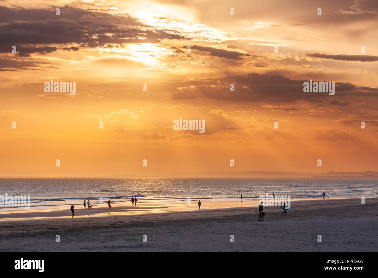 Les gens silhouettes sur la plage de l'océan au coucher du soleil en été en Australie Banque D'Images