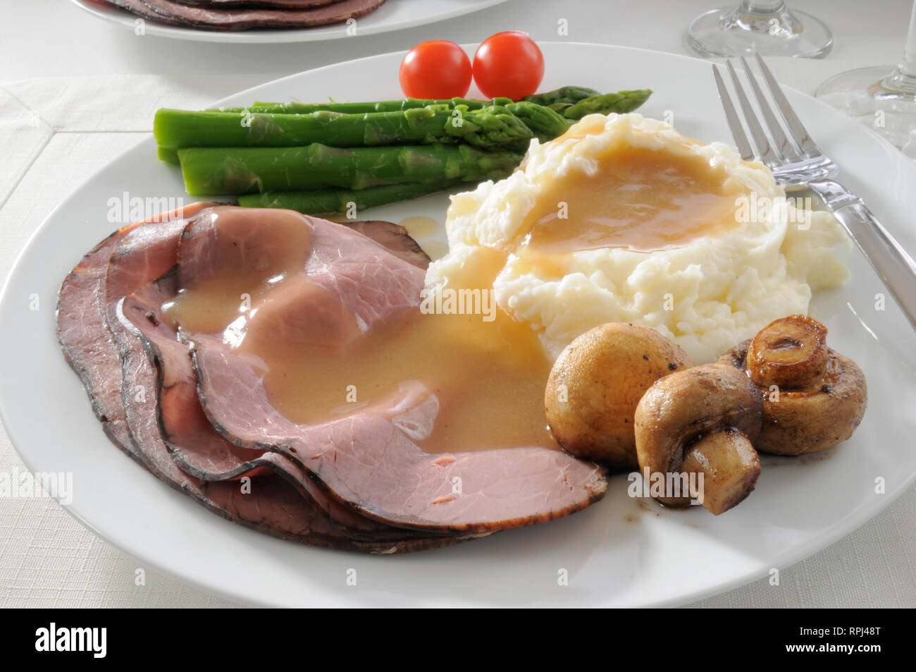 Une assiette de fines tranches de rôti de bœuf aux asperges et sa purée de pommes de terre Banque D'Images