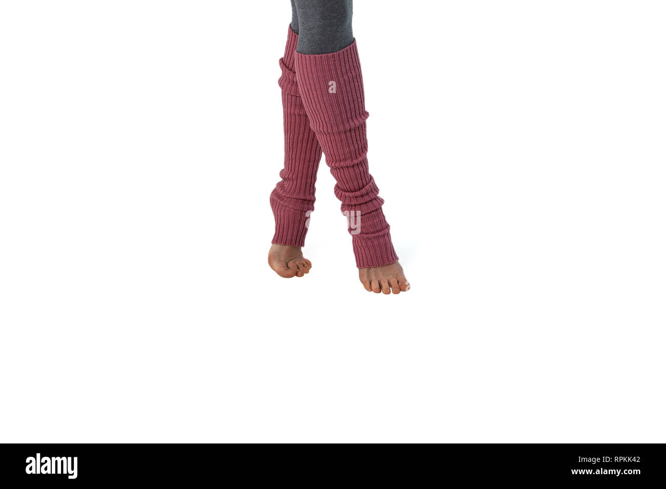 Jeune Fille en rose jambières, engagés dans pilates debout sur les doigts. Fond blanc. Banque D'Images