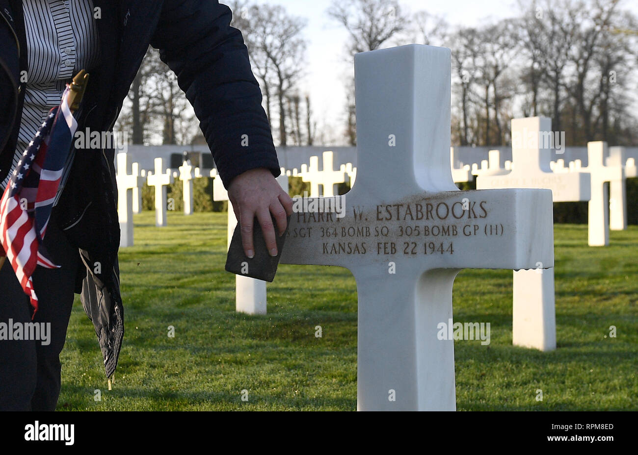 La tombe du Sergent d'Harry Estabrooks, qui ont péri avec neuf autres quand son bombardier B-17, nommé 'Mi Amigo', s'est écrasé à Sheffield Endcliffe Park en 1944, est décorée avec du sable d'Omaha Beach en Normandie avant une cérémonie de dépôt de gerbes au cimetière Américain de Cambridge, Cambridgeshire en coton. Banque D'Images