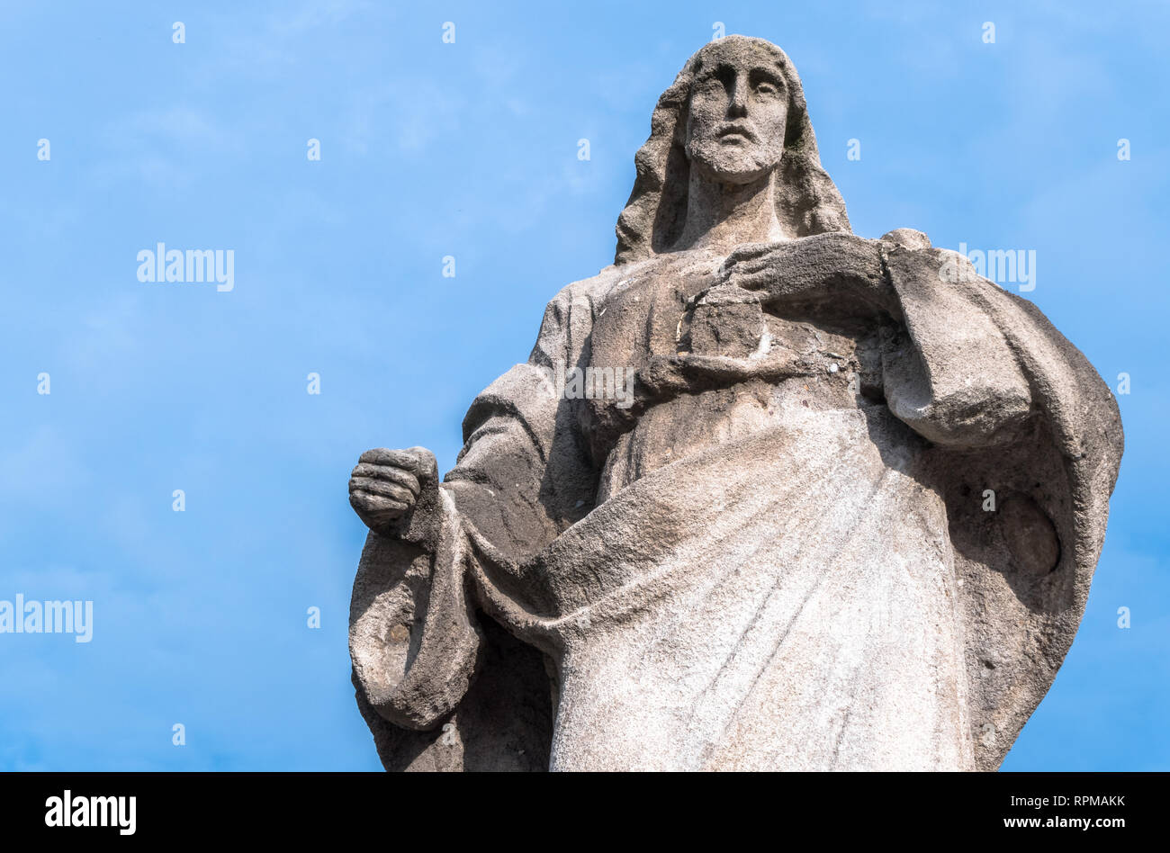 Statue de pierre du Sacré-Cœur de Jésus. Jésus Christ de la sculpture sur pierre avec cœur sur fond de ciel bleu. Idéal pour le concept de Pâques et d'autres. Banque D'Images