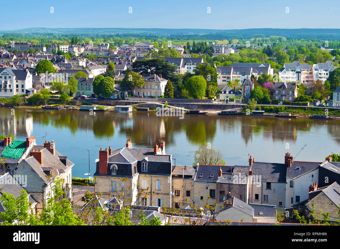 Vue imprenable sur la petite ville étonnante Saumur, France. De nombreuses maisons blanches et grises près d'un fleuve Loire, beaucoup d'arbres et toits verts. Printemps Chaud m Banque D'Images