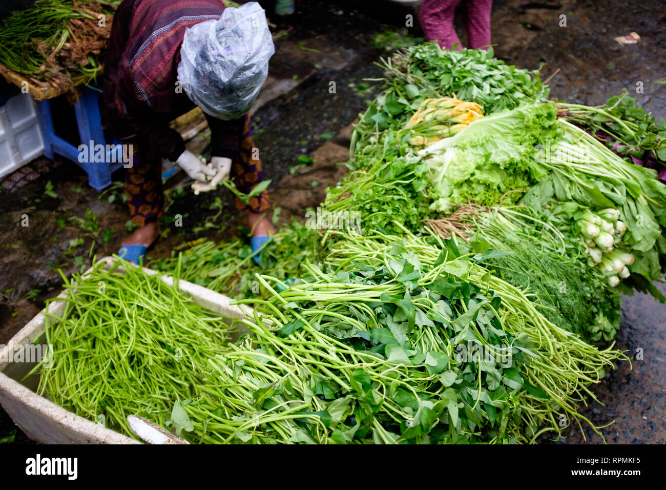 2 janvier 2019, Ho Chi Minh City, Vietnam - une dame vendant des légumes verts à un marché de rue. Banque D'Images