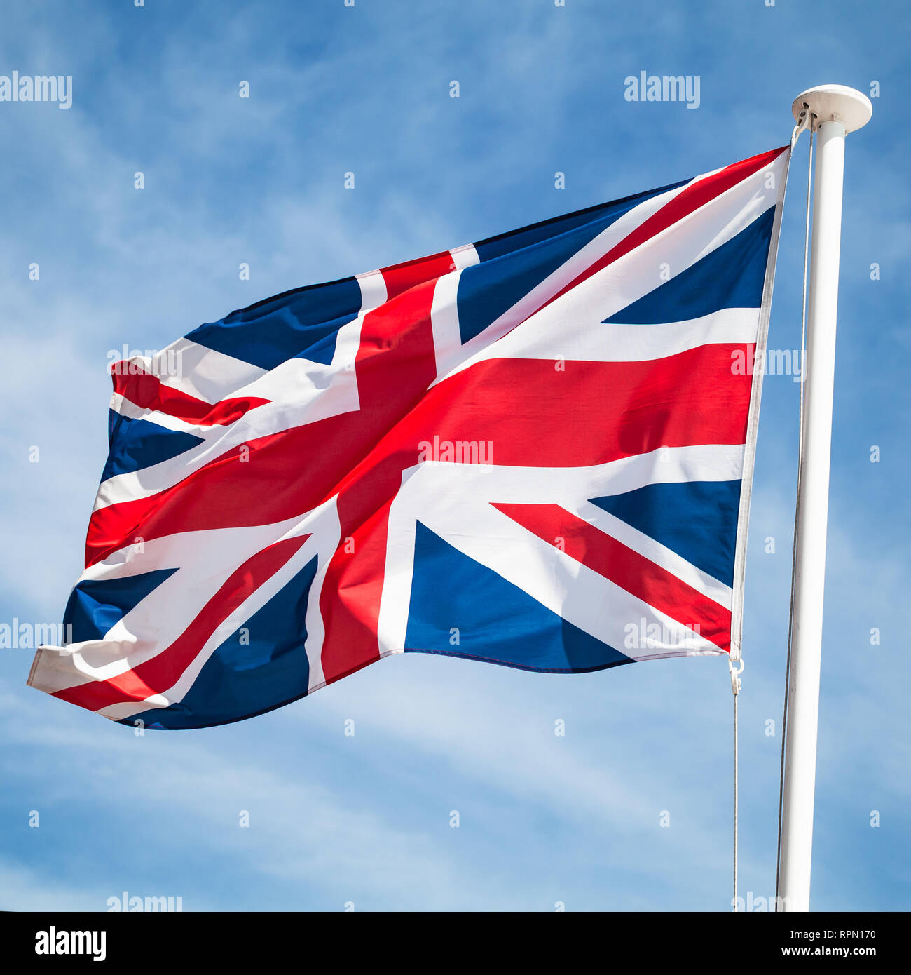 Le drapeau national du Royaume-Uni ou Union Jack, également connu sous le nom de l'Union européenne drapeaux sur le vent sur fond de ciel bleu. Square photo Banque D'Images