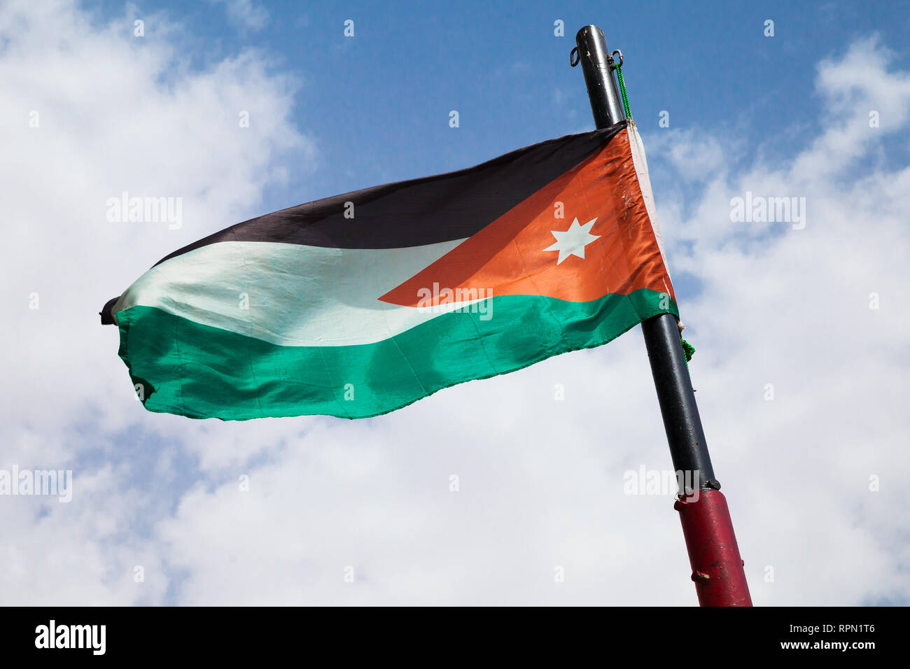 Drapeau de la Jordanie forme sur fond de ciel bleu nuageux Banque D'Images