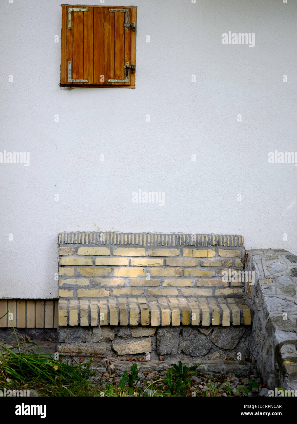 Banc de brique sur un mur de maison. Banque D'Images