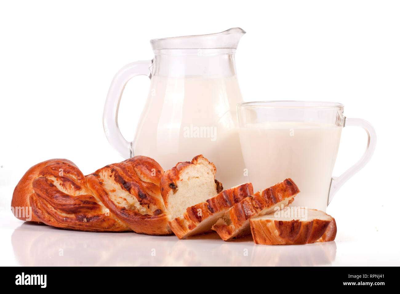 Verseuse et verre de lait avec une miche de pain isolé sur fond blanc Banque D'Images