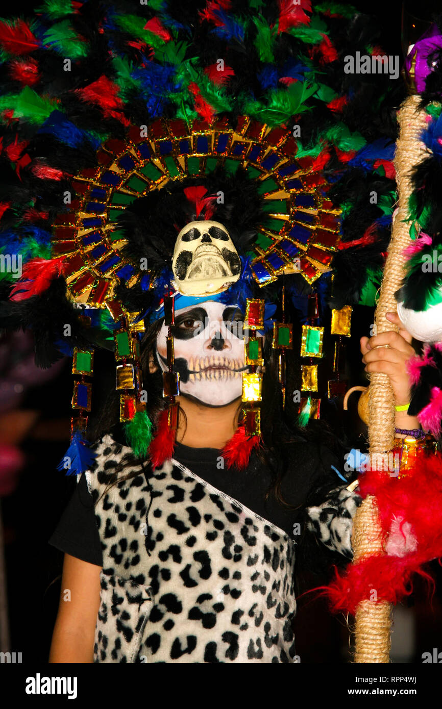 Jeune garçon déguisé, fortement colorés avec des plumes et du crâne, le port du masque maya leopard outfit, debout dans la rue au cours de l'assemblée annuelle cele mexicain Banque D'Images