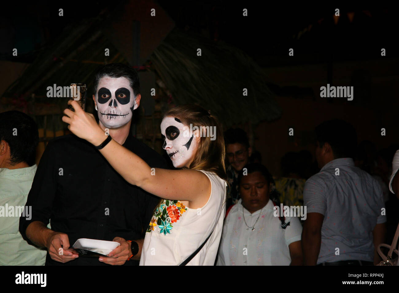 Culturel et Touristique au cours de la Dia de los Muertos, deux touristes avec face crâne en sucre composent prennent un pendant selfies célébration annuelle de la Banque D'Images