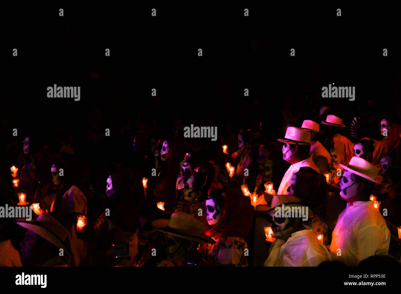 Le jour de la fête des morts, défilé de nuit au Mexique, les gens défilent avec tête de visages et costumes traditionnels mexicains, tenant des bougies. Banque D'Images