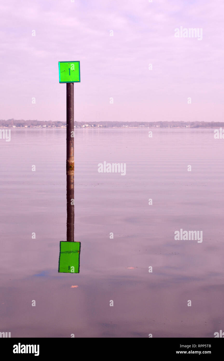 Un marqueur de canal vert avec son reflet dans la baie de Chesapeake, près de Baltimore, Maryland Banque D'Images