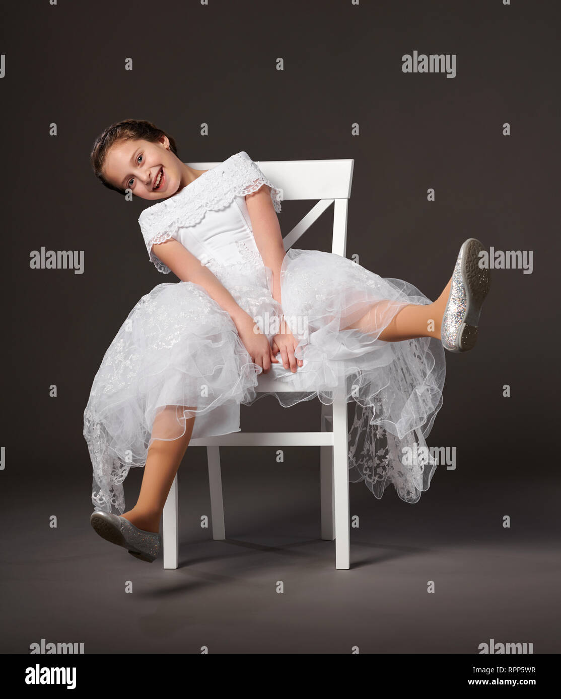 Portrait D'une Petite Fille De 2 Ans En Vêtements Habillés Assis Sur La  Chaise