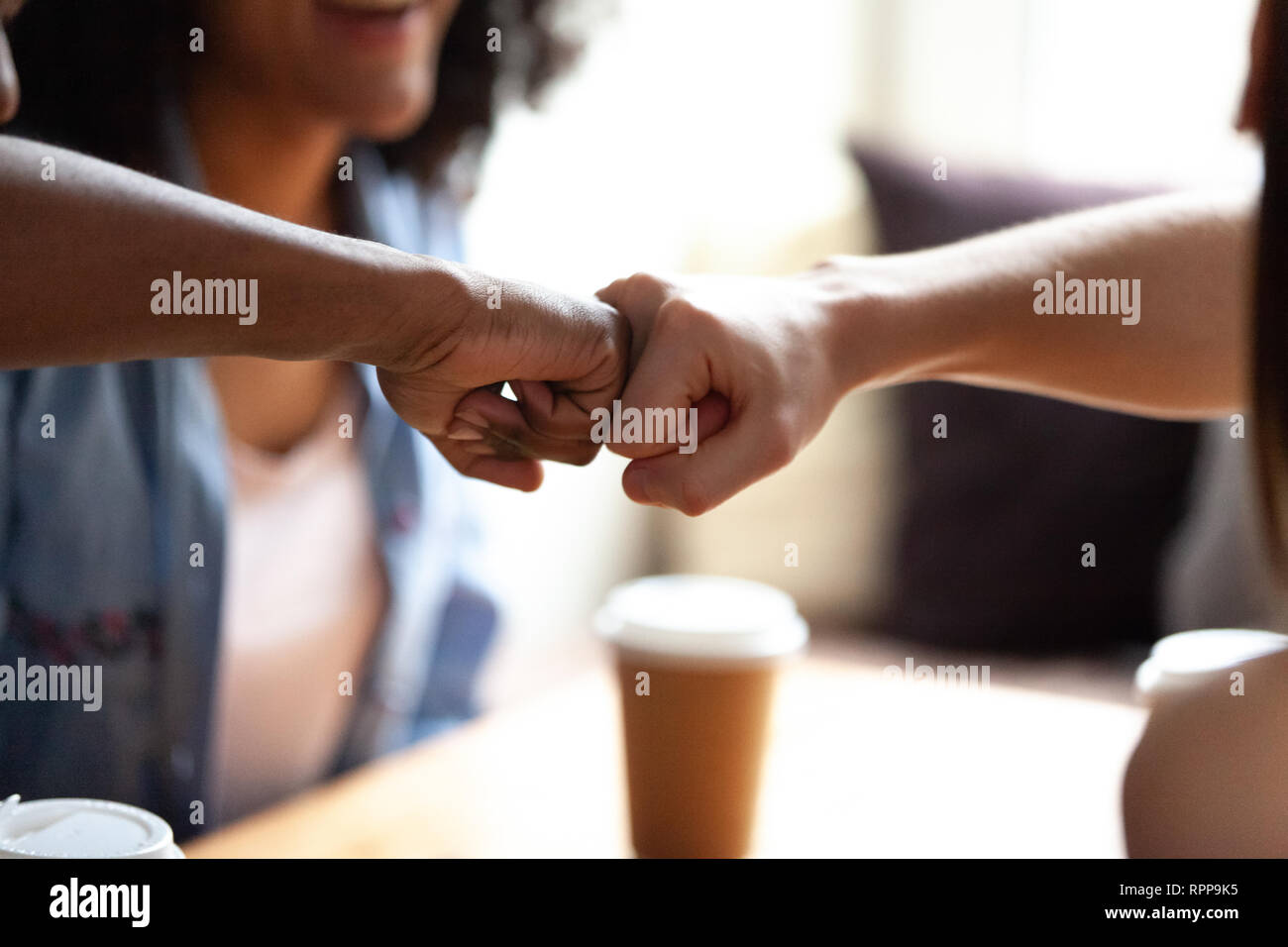 Close up amis multiraciale fist bumping, célébrer les succès de cafe Banque D'Images