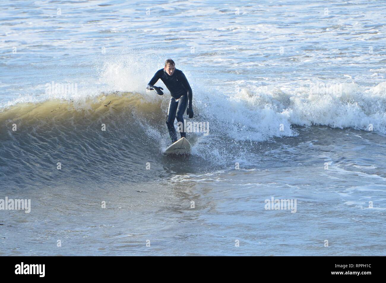 Pays de Galles Aberystwyth UK. Vendredi 22 Fév 2019 UK weather : Surfers appréciant le soleil Février incroyablement chaude à Aberystwyth, sur la côte ouest du pays de Galles. Le temps devrait rester très bien pour les prochains jours avec la possibilité d'enregistrer les températures ont dans certains endroits Crédit photo : Keith morris/Alamy Live News Banque D'Images