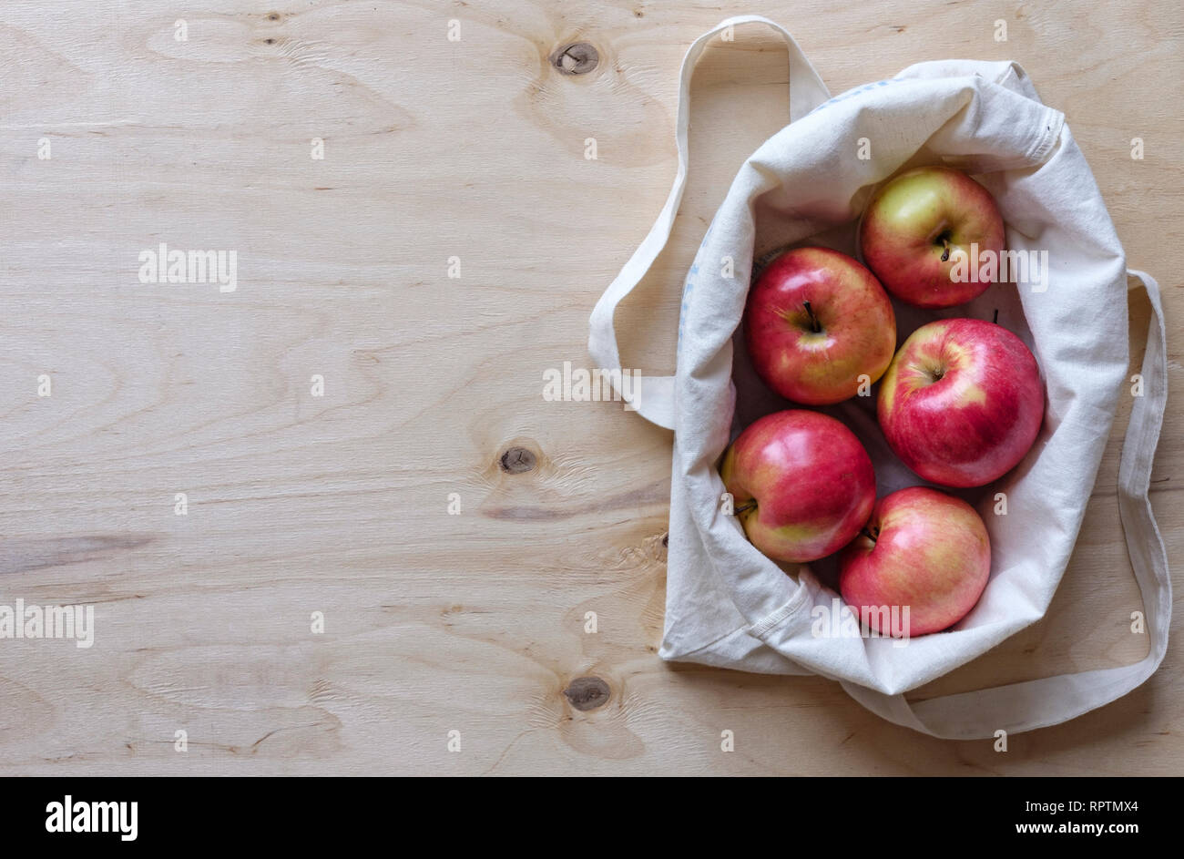 Des pommes juteuses affiché dans un sac de tissu sur un panneau de fond avec copie espace Vue de dessus Banque D'Images