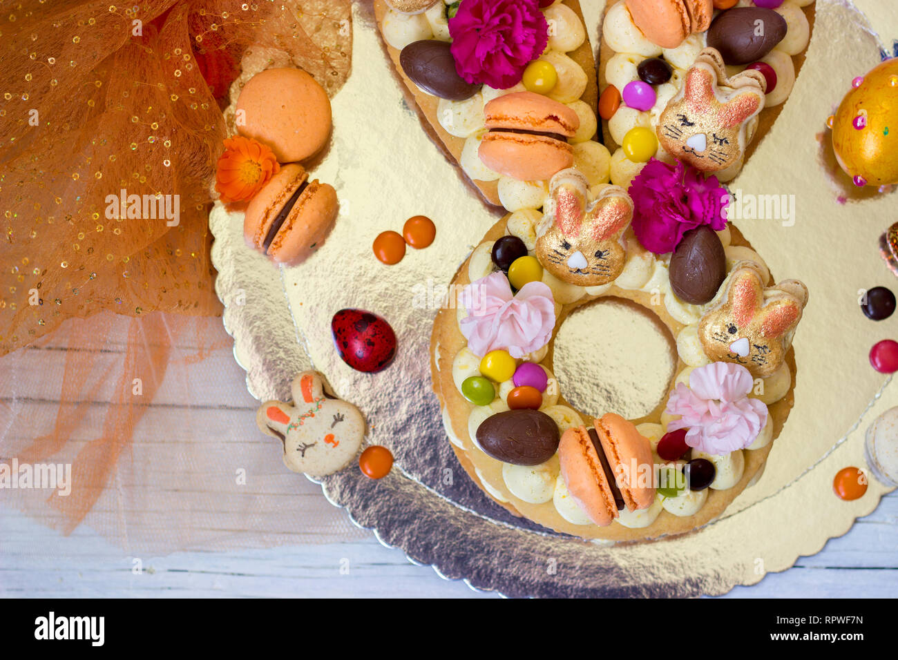 Gâteau de Pâques à la vanille, en forme de lapin de Pâques, décorées de fleurs et macarons Banque D'Images