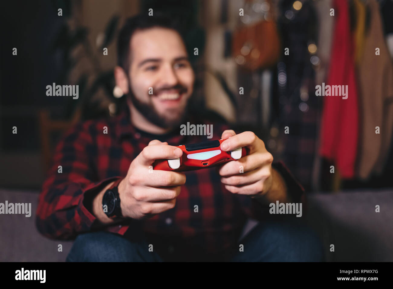 Portrait d'un jeune homme les jeux, jouer à des jeux vidéo, gagner et célébrer. L'accent sur le joystick. Banque D'Images