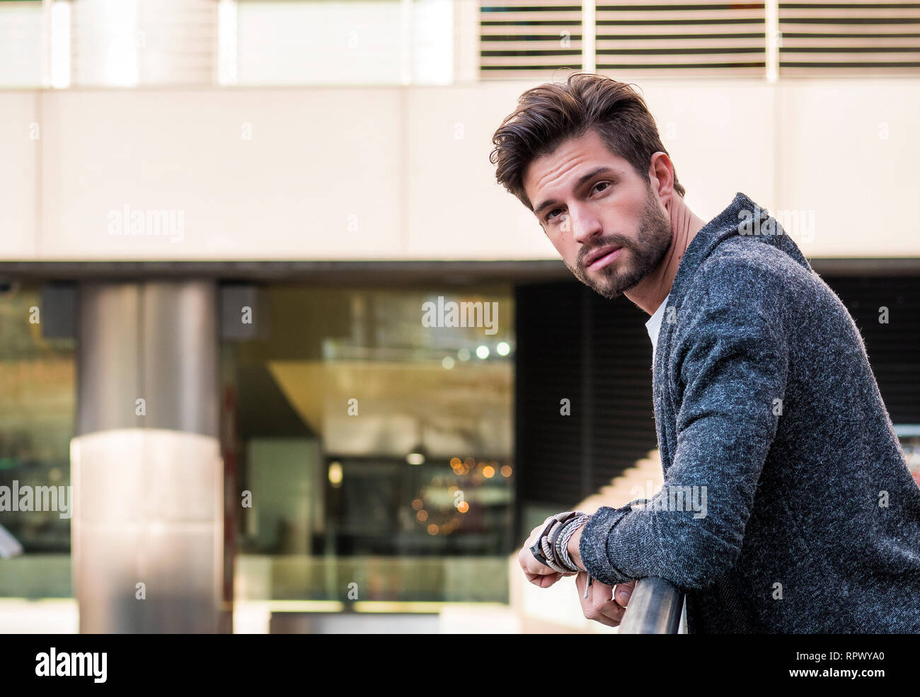 Un homme séduisant dans l'environnement de la ville de porter cardigan Banque D'Images