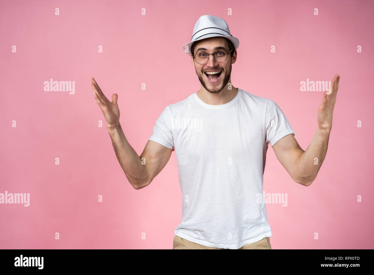 Surpris, l'homme heureux expressif isolé sur rose. Banque D'Images