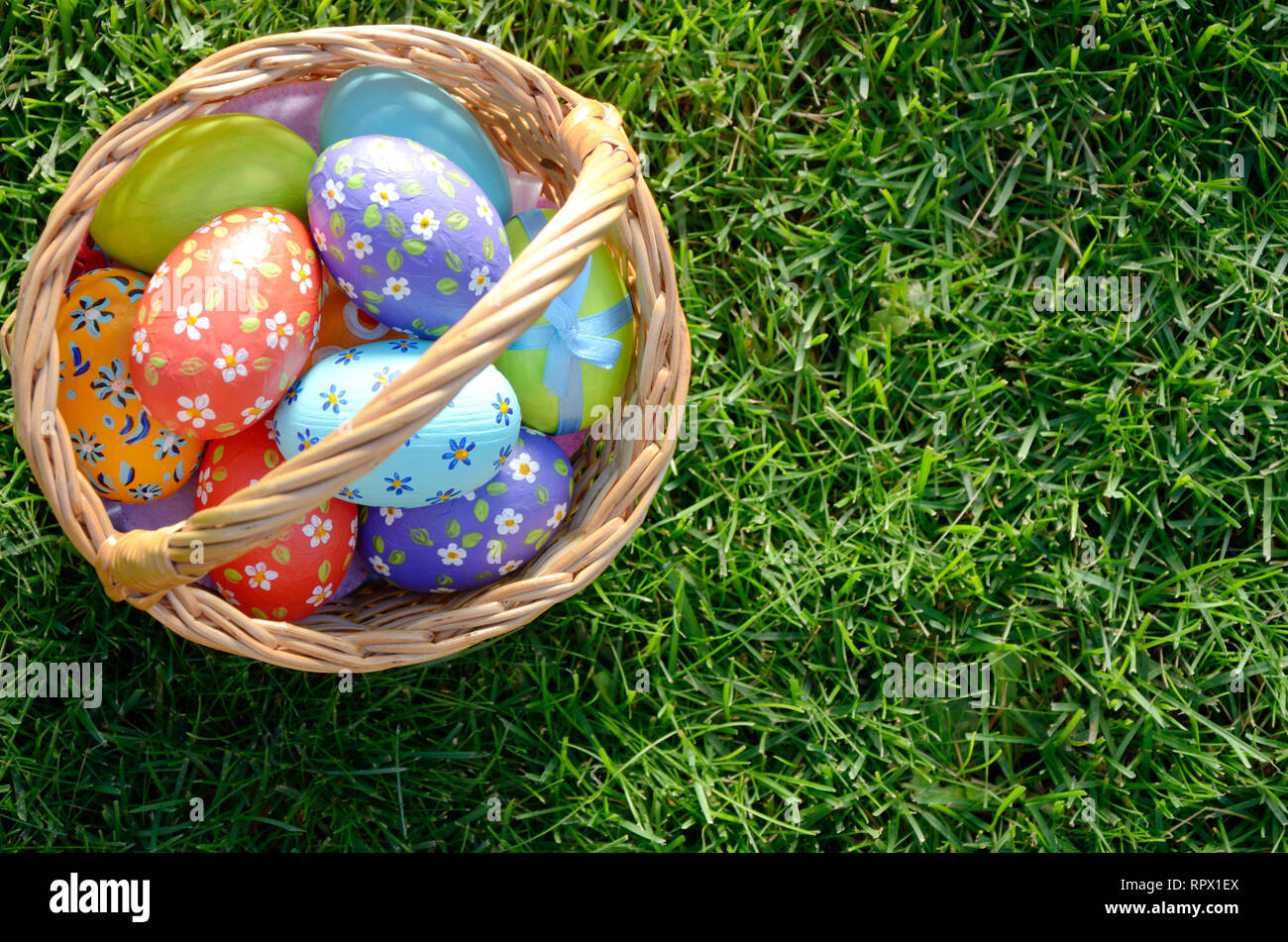 Télévision jeter coup d'œufs de Pâques dans le panier en osier sur green spring grass. Un espace réservé au texte Banque D'Images