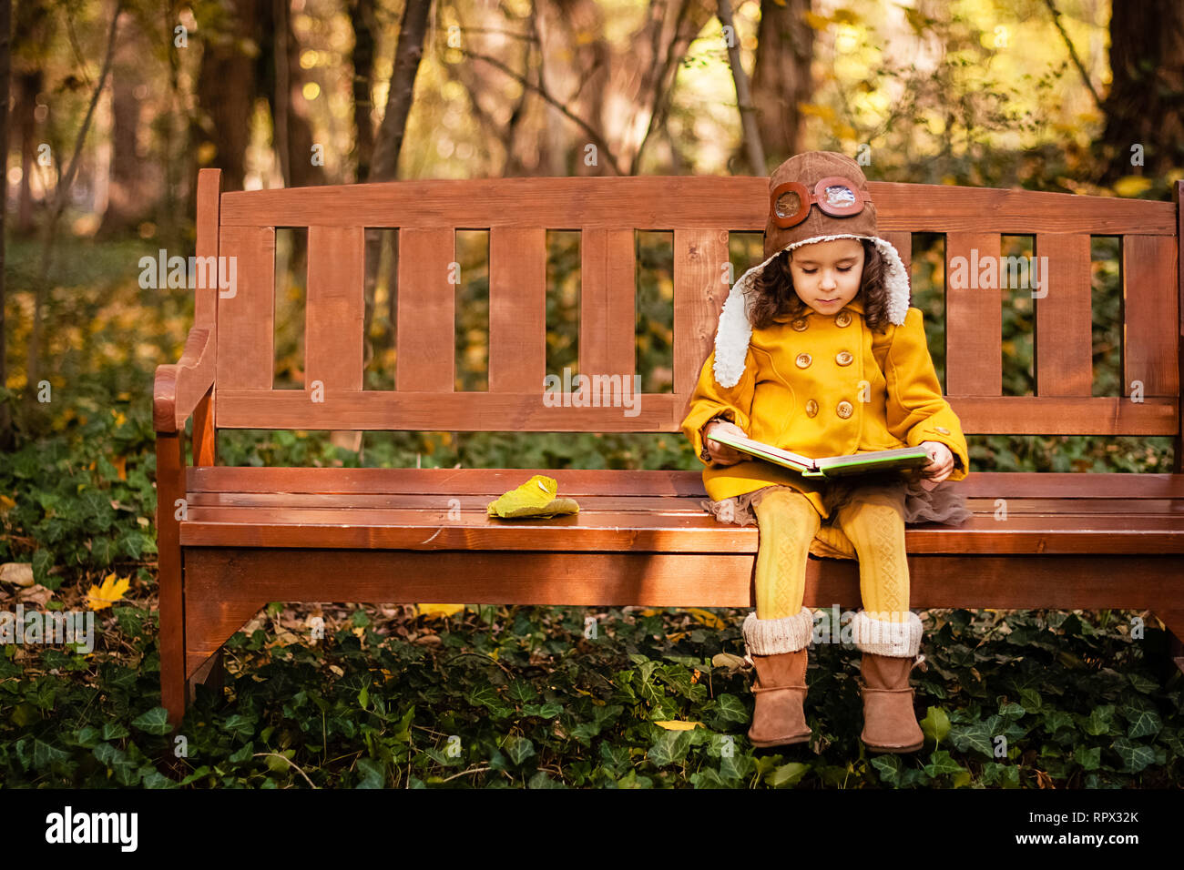 Fille assise sur un banc de parc en lisant un livre, en Bulgarie Banque D'Images
