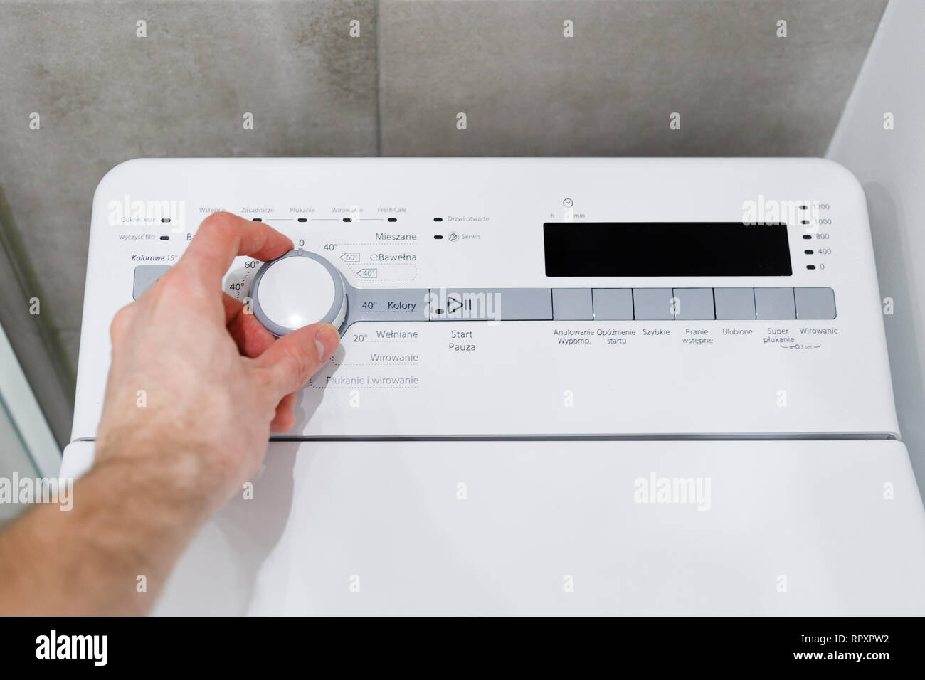 La main de l'homme met en place sur le mode machine à laver verticale Photo  Stock - Alamy