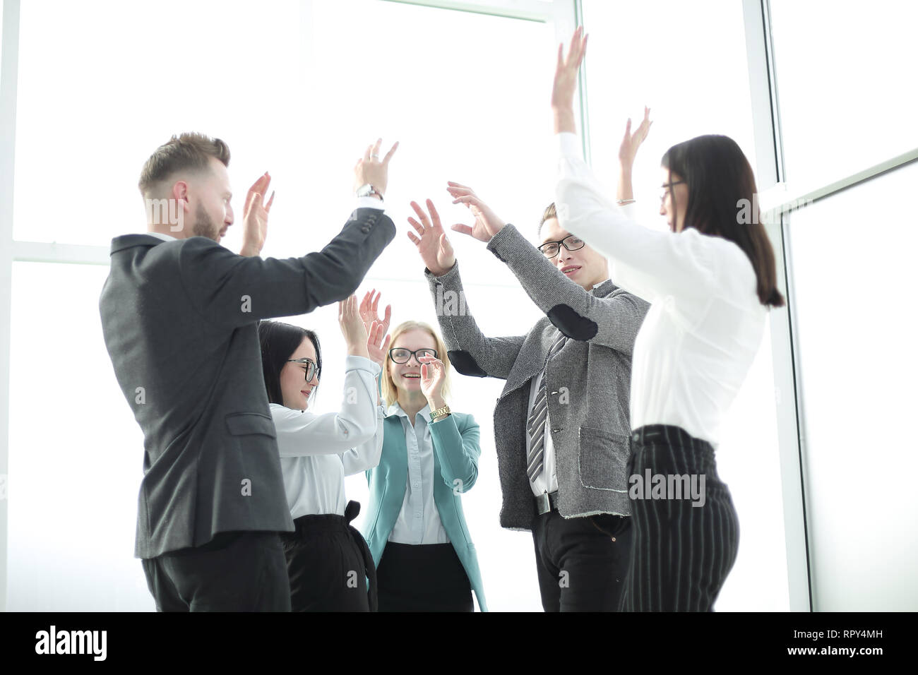 L'équipe d'affaires se réjouit, debout dans le bureau. Banque D'Images