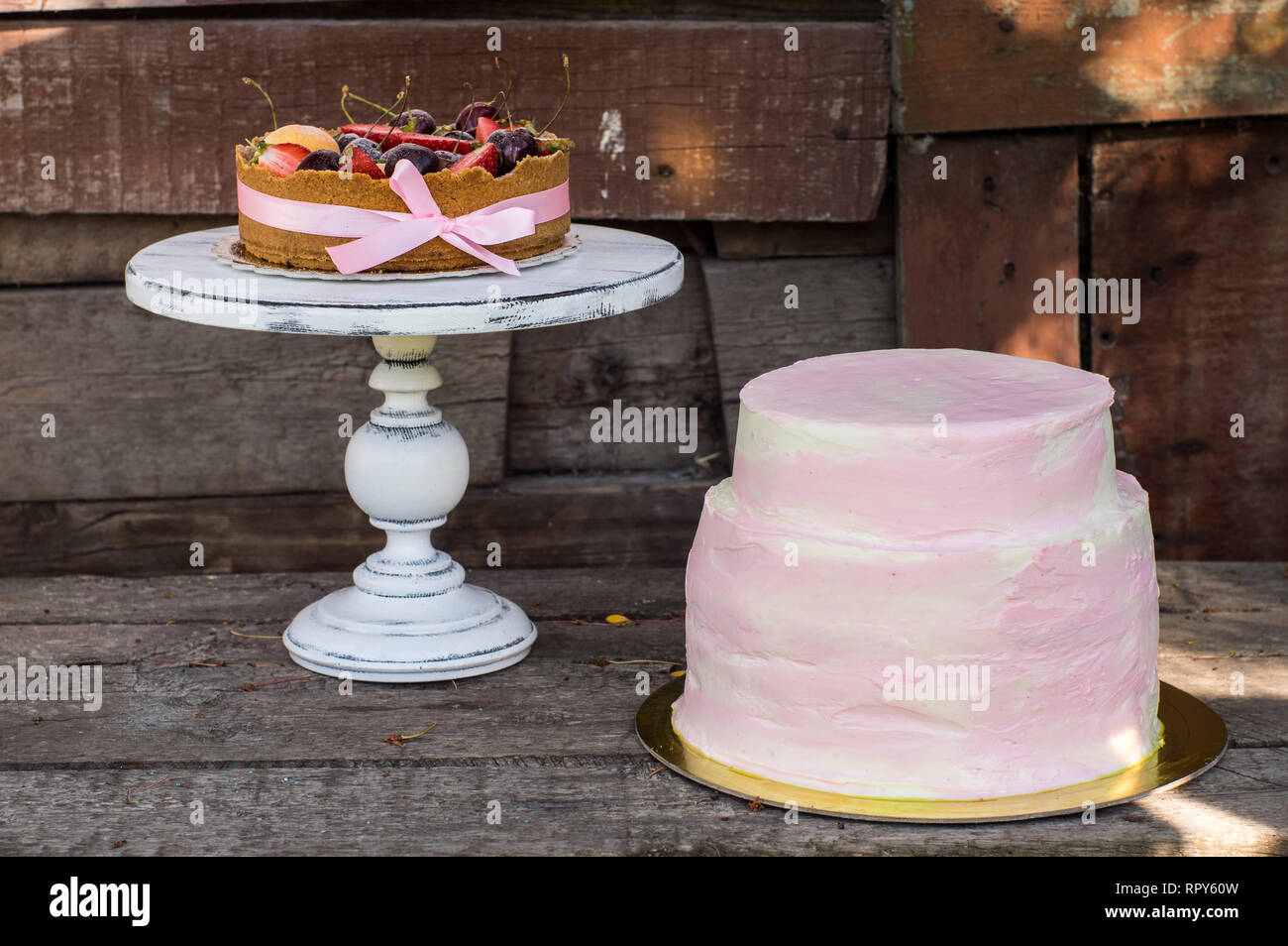 Gâteau au fromage avec fruits et de baies et big pink gâteau sur le noeud rose blanc bandes, Banque D'Images