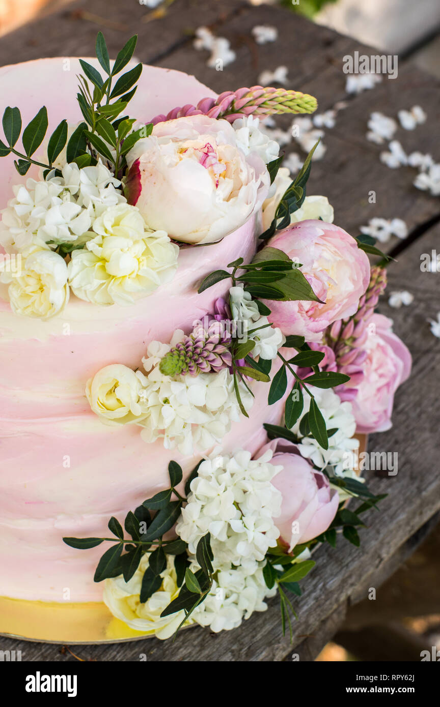 Big Pink gâteau de mariage décoré de fleurs naturelles Banque D'Images