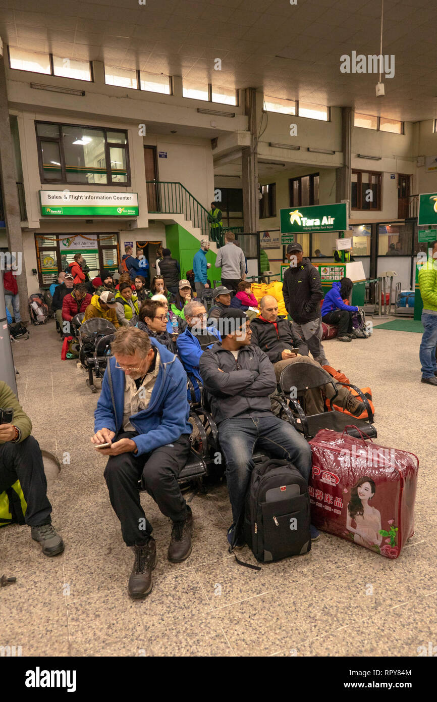 Le Népal, Katmandou, l'aéroport international de Tribhuvan, zone de départ de l'intérieur, les passagers assis en attente de retards de vols à Lukla Banque D'Images
