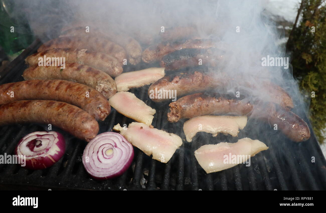 Saucisses de porc, bacon et oignons rouges grillés sur charbon de bois, une cuisine traditionnelle bulgare. Barbecue Banque D'Images