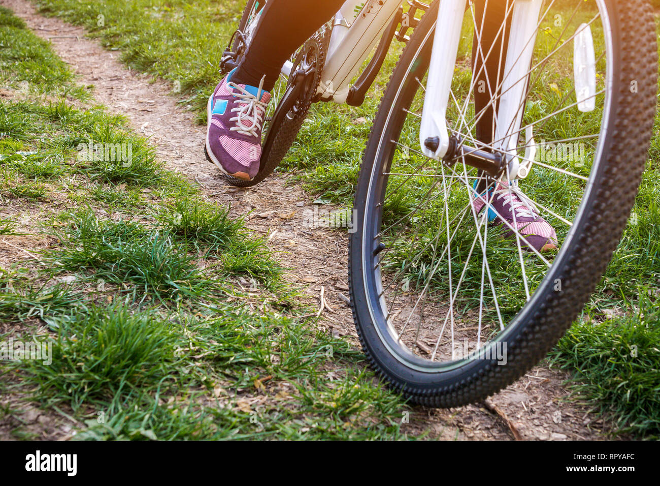 La jambe féminine sur la pédale du vélo dans la forêt Banque D'Images