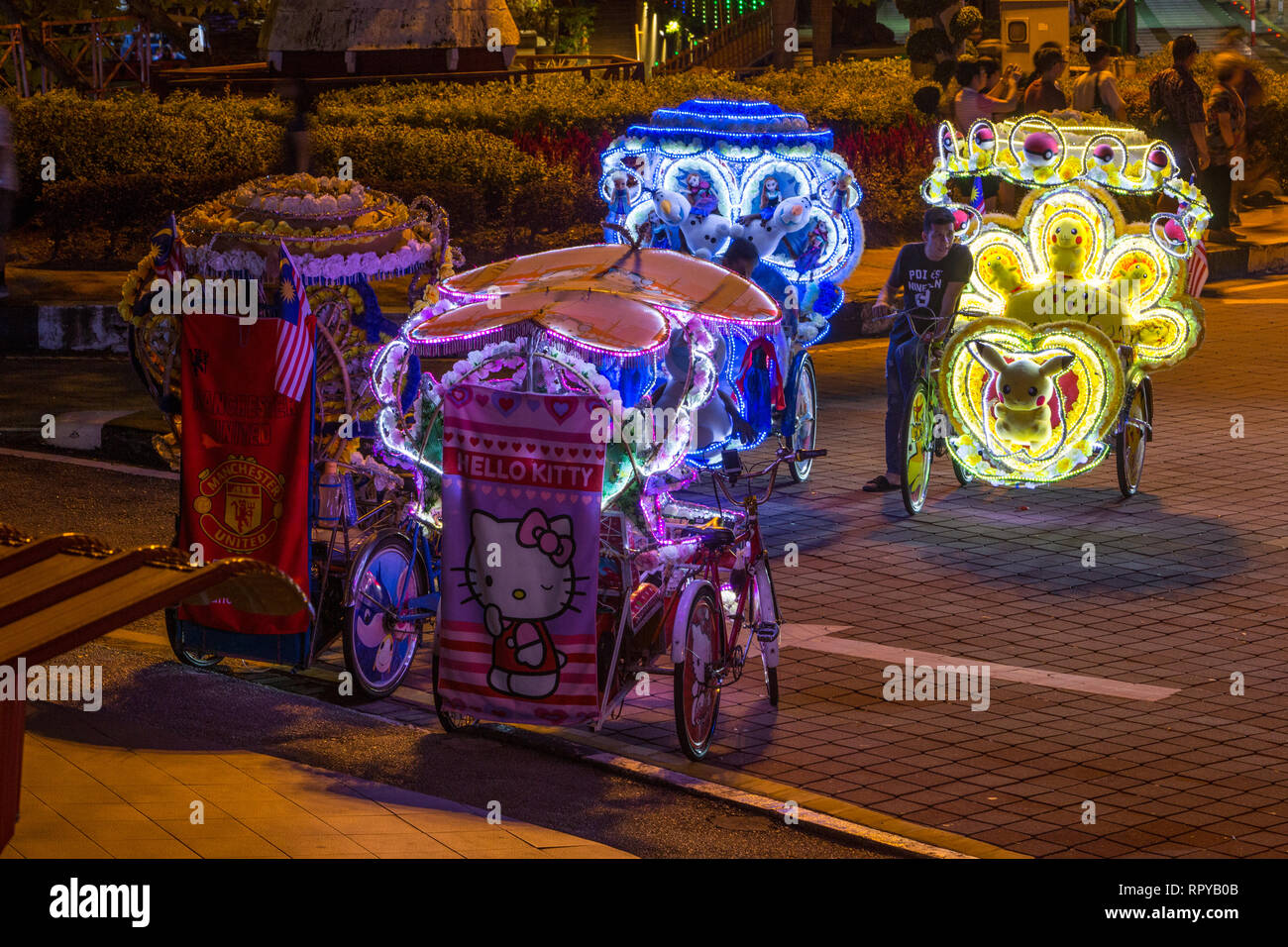 Les pilotes Trishaw en attente de clients touristiques de nuit, Melaka, Malaisie. Banque D'Images