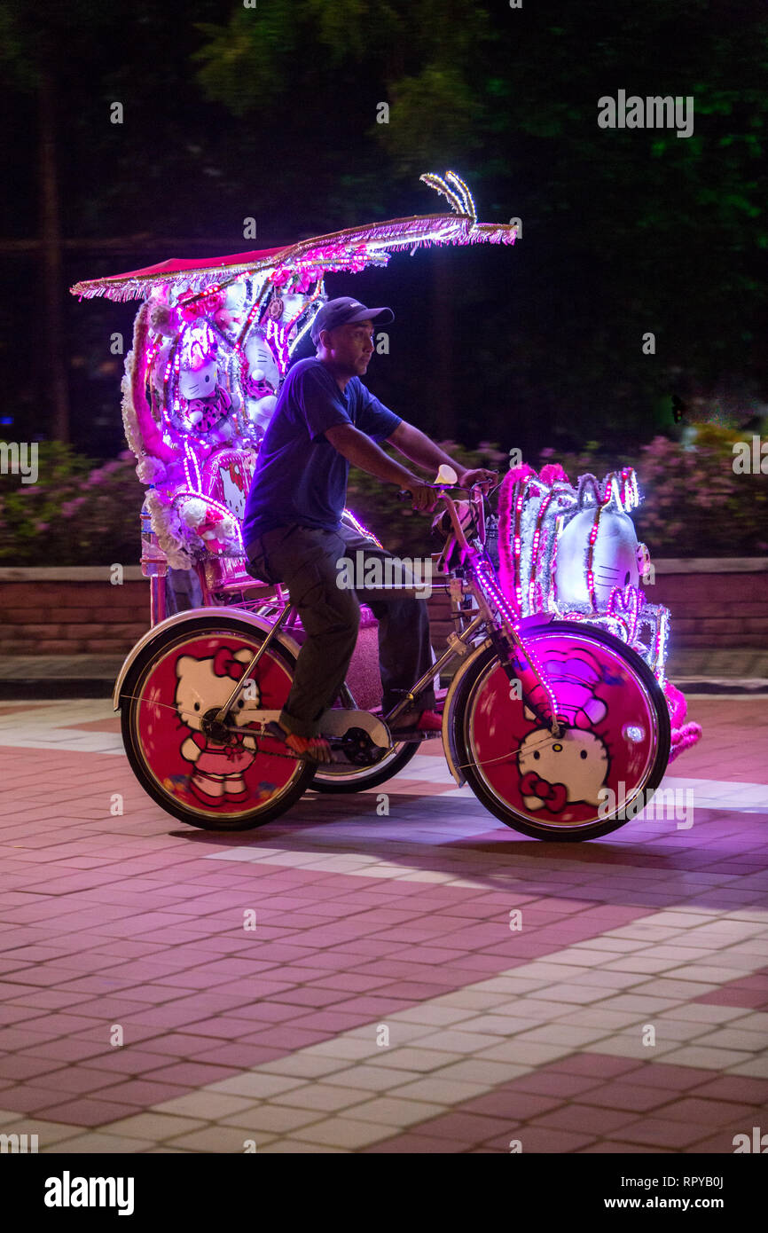 Pilote Trishaw la nuit, Melaka, Malaisie. Banque D'Images