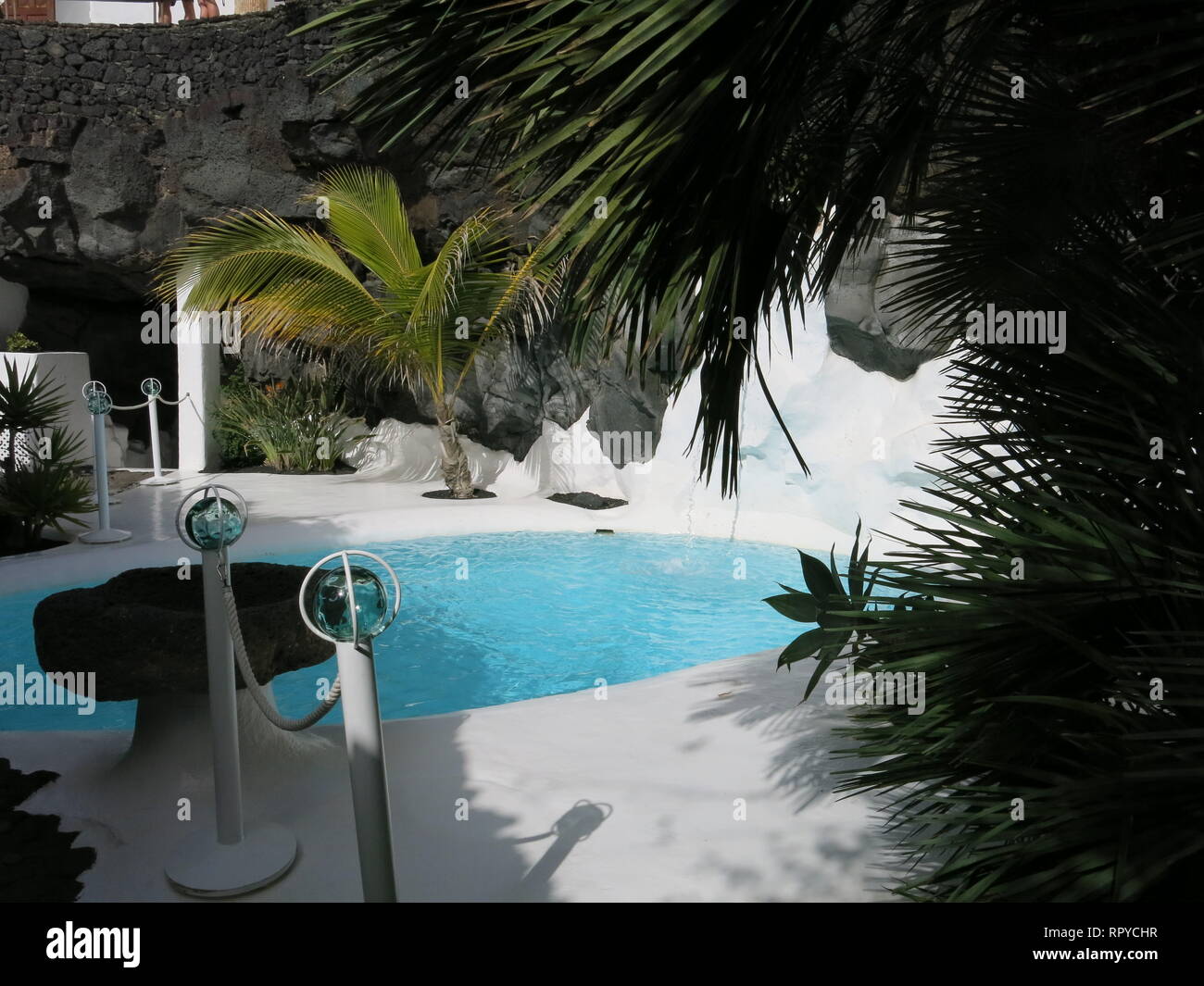 De la piscine au Cesar Manrique ; l'ancienne maison de l'eau turquoise contraste avec un blanc brillant et revêtement de murs de roches noires Banque D'Images