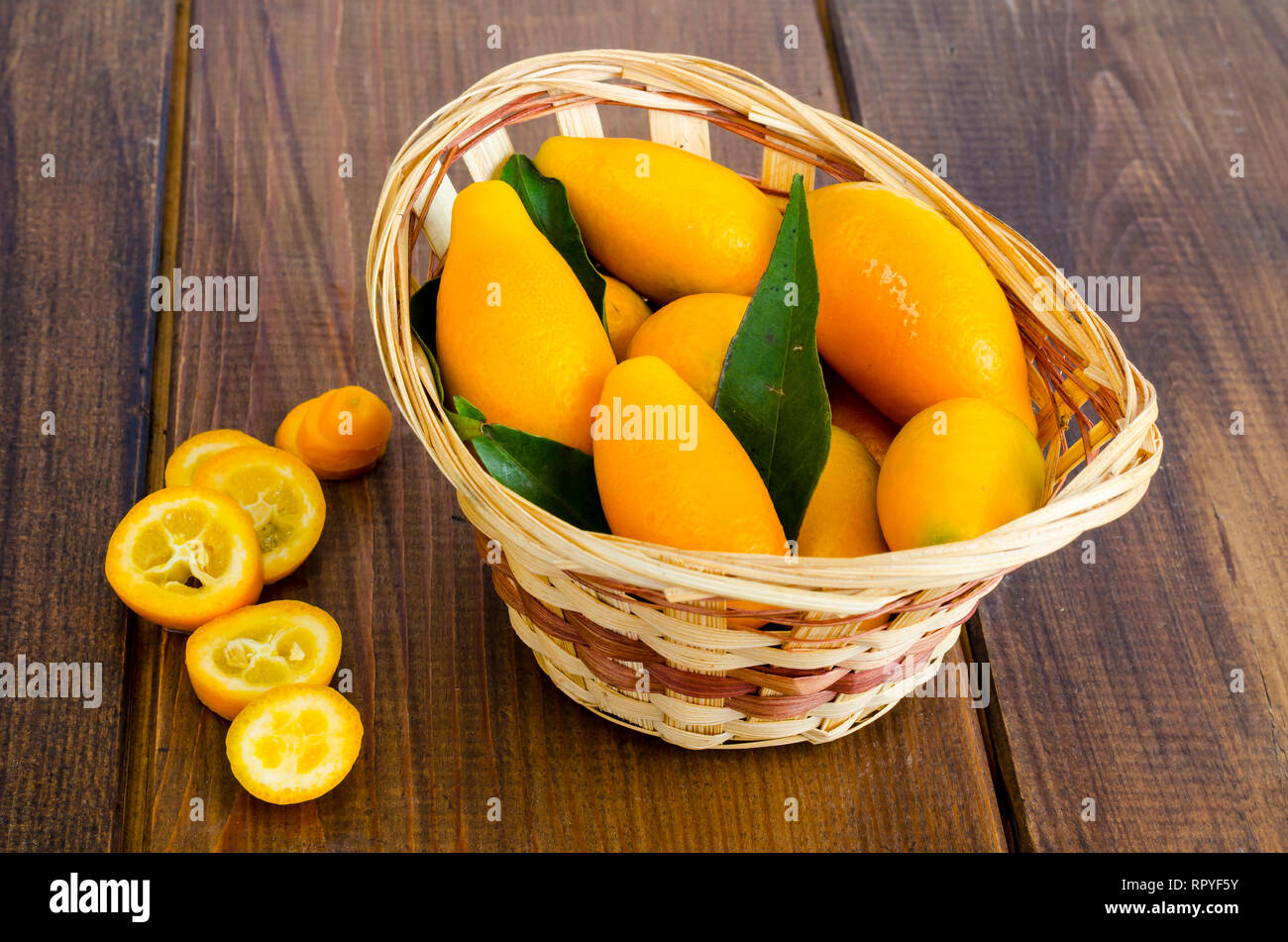 Le kumquat fortunella mûrs sweet orange dans le panier en bois. Studio Photo Banque D'Images