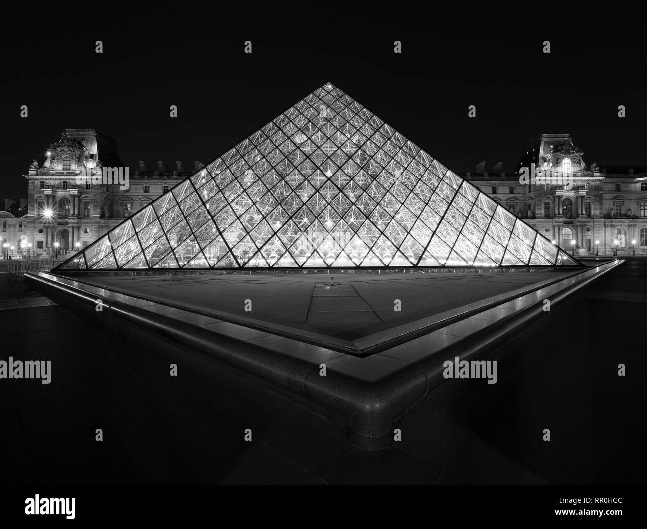 La pyramide du Louvre a été voulu par l'IPE et est un spectacle magnifique lorsqu'il est illuminé en soirée. Banque D'Images