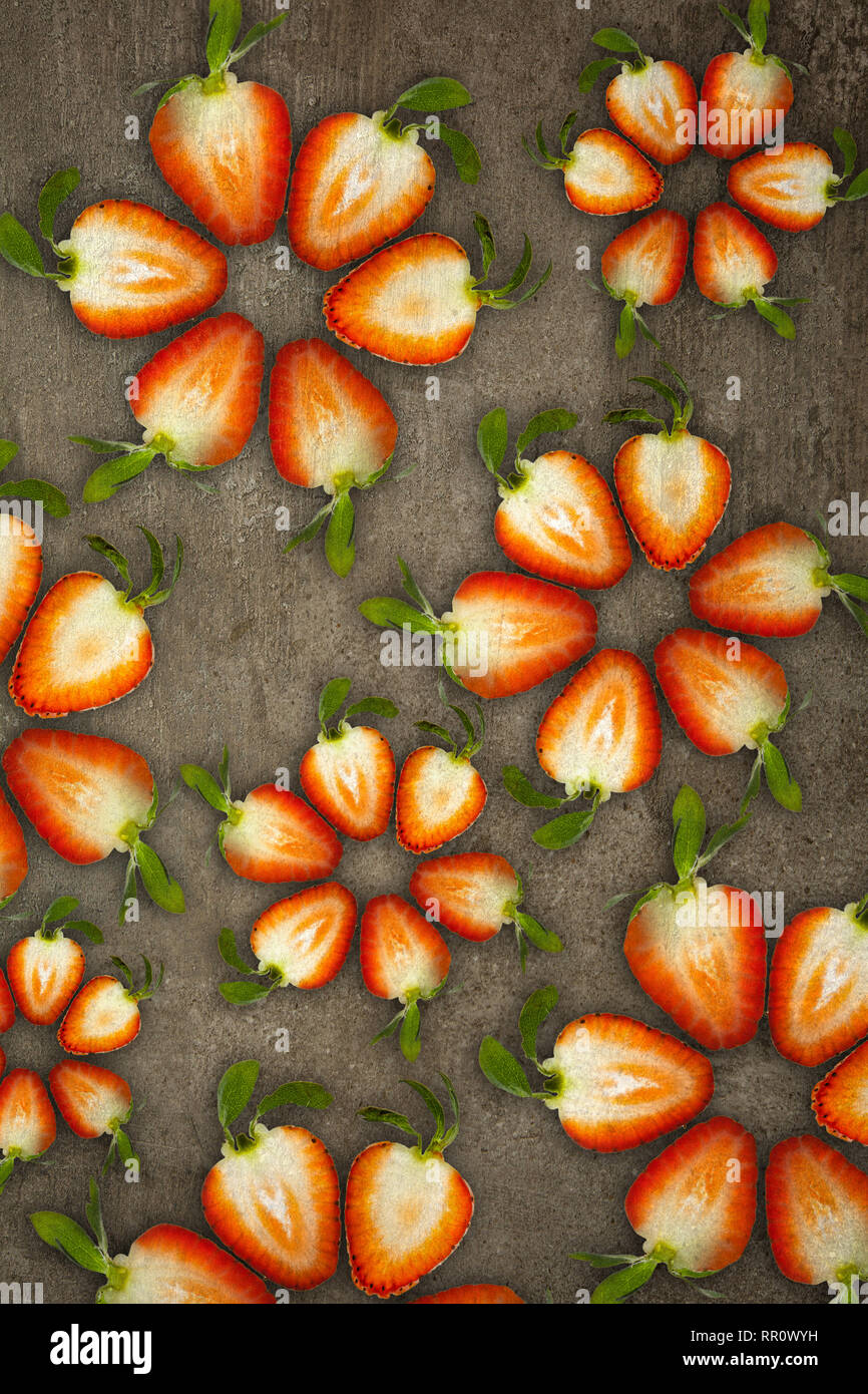 Fleurs créatif fait de fraises découpées dans ci-dessous allumé sur un fond de pierre concept alimentaire Banque D'Images