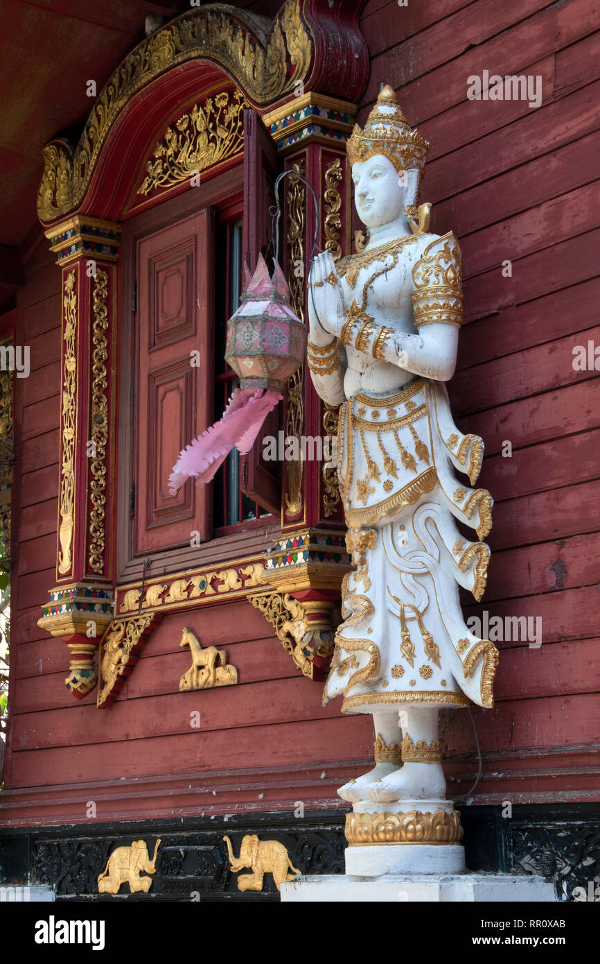 Chiang Rai, Thaïlande holding statue en lanterne rouge de l'avant-mur à Wat Ming Muang Banque D'Images