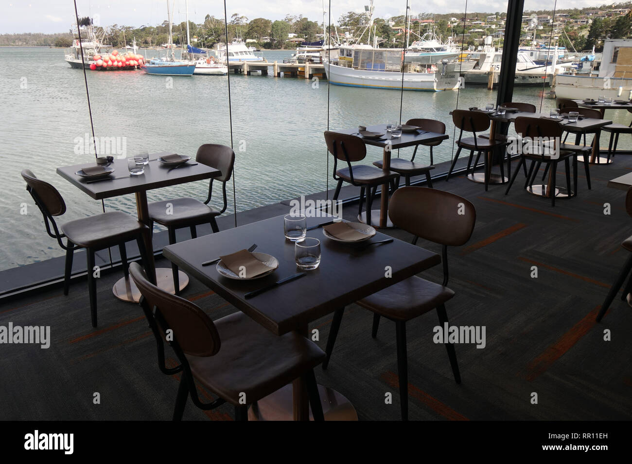 Tables avec vue sur l'eau prêt pour vous au quai Bar & Kitchen, St Helens, Tasmanie, Australie. Pas de PR Banque D'Images