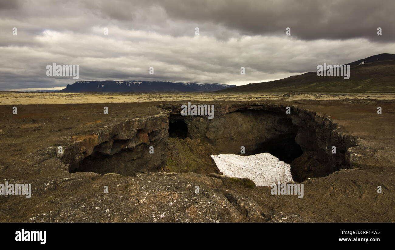 Grotte de lave Surtshellir-en dans l'intérieur de hautes terres d'Islande avec ciel couvert. Banque D'Images