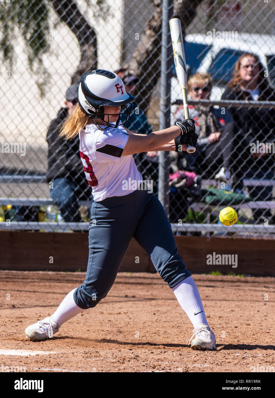 En softball uniforme blanc suite à des bat swing lors match entre la technologie Foothill High School et Pioneer Valley le 23 février Banque D'Images