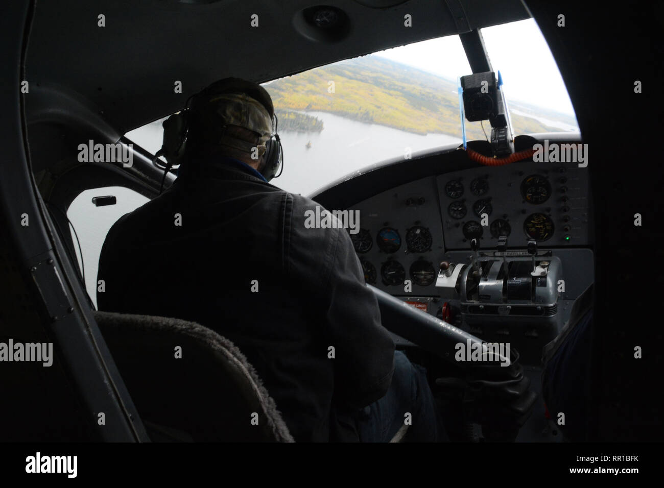 Un pilote d'hydravion du poste de pilotage d'un aéronef, en survolant le lac rempli de la forêt boréale du nord de la Saskatchewan, près de Stanley Mission, le Canada. Banque D'Images