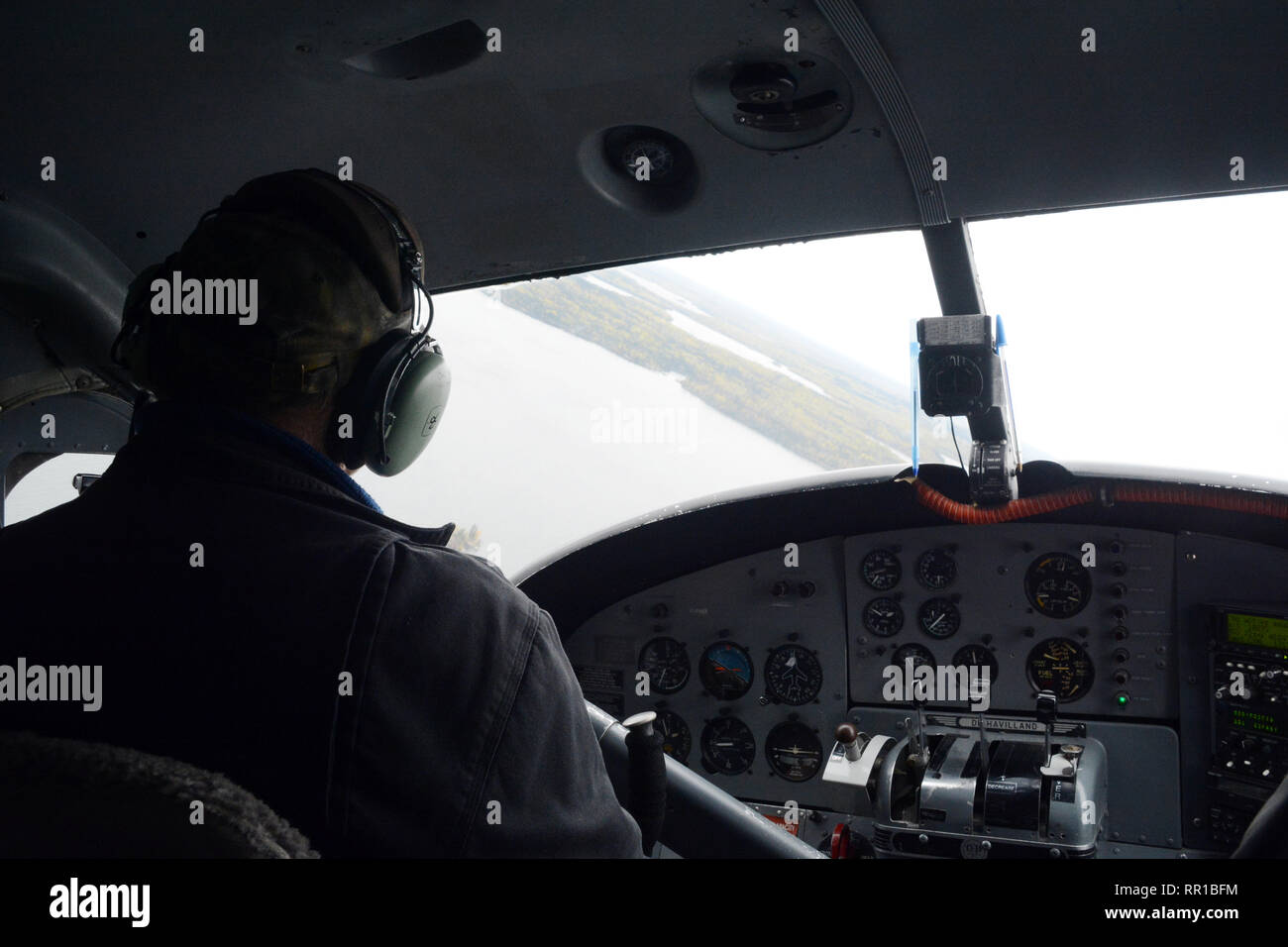 Un pilote d'hydravion du poste de pilotage d'un aéronef, en survolant le lac rempli de la forêt boréale du nord de la Saskatchewan, près de Stanley Mission, le Canada. Banque D'Images