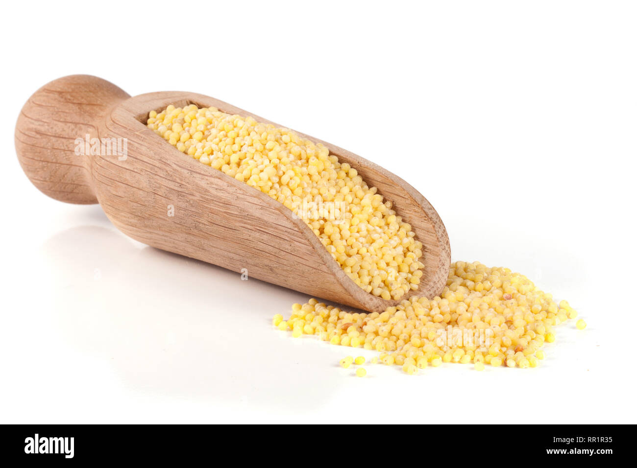 Millet dans une pelle en bois isolé sur fond blanc Banque D'Images