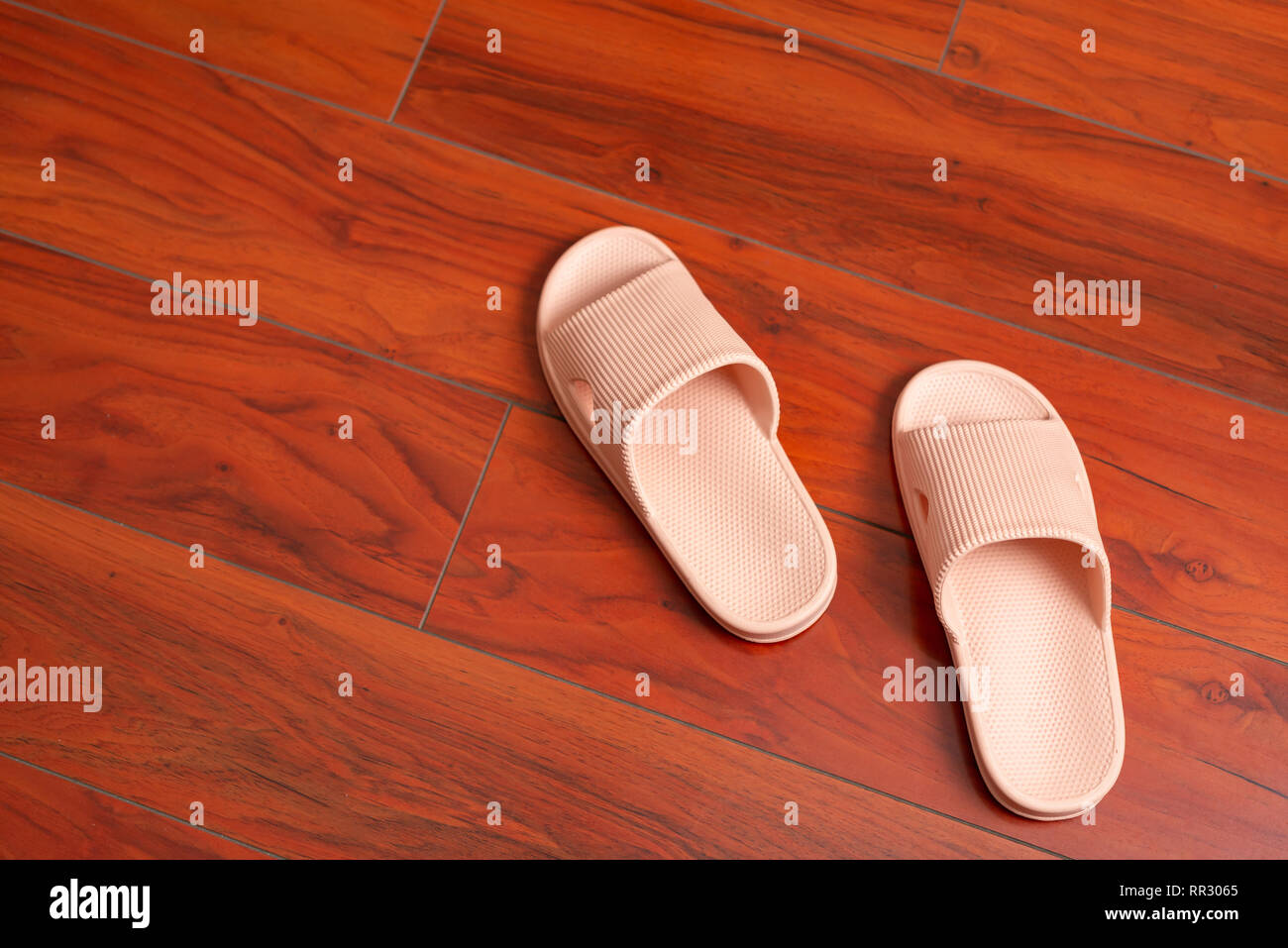 Paire de chaussons rose sur un plancher en bois Banque D'Images