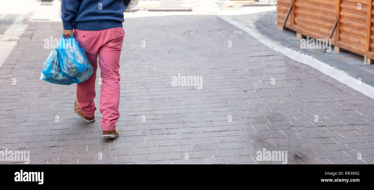 L'utilisation des sacs en plastique. Homme hoding sacs en plastique bleu. Vue rapprochée, copy space Banque D'Images