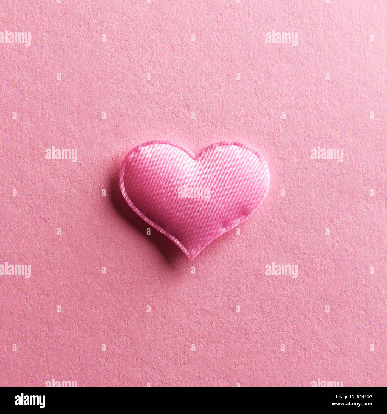 Coeur textile rose sur fond rose. La texture et de l'amour Saint-valentin concept Banque D'Images